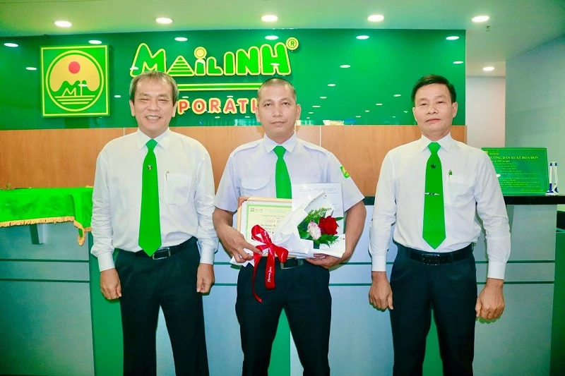 Ông Trương Quang Mẫn (trái) - Phó Tổng giám đốc Thường trực Tập đoàn Mai Linh, trao khen thưởng cho lái xe Nguyễn Minh Hải.