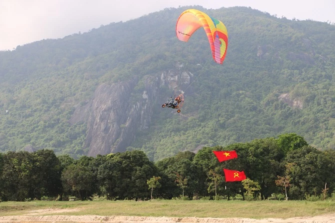 Dù lượn có động cơ kéo cờ tổ quốc trên bầu trời Phụng Hoàng Sơn thực hiện nghi thức khai mạc, chào mừng kỷ niệm 48 năm ngày Giải phóng miền Nam, thống nhất đất nước (30/4/1975 - 30/4/2023) và ngày Quốc tế lao động 1/5.