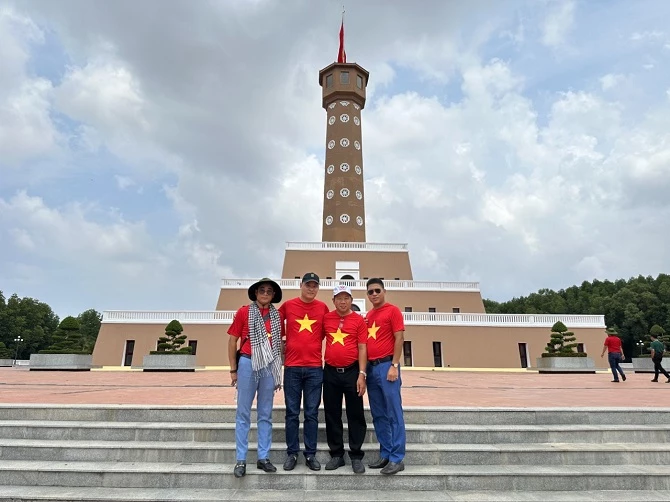 Du khách chụp ảnh lưu niệm dưới cột cờ Hà Nội tại mũi Cà Mau.