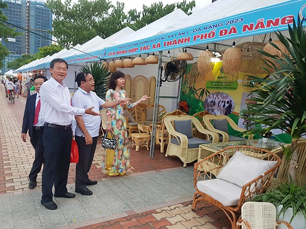 Ông Phạm Công Chính, Chủ tịch Liên minh HTX Đà Nẵng (ngoài cùng, áo trắng, đeo kính) đến thăm gian hang và động viên các HTX của Đà Nẵng tham gia phiên chợ sản phẩm HTX lần 1