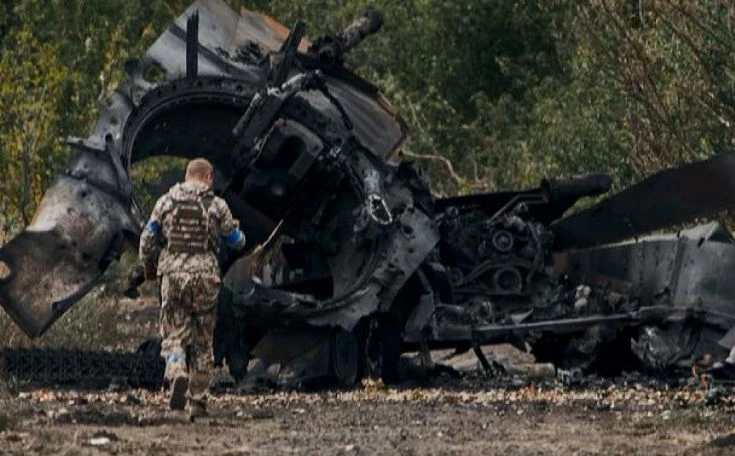 Một người lính Ukraine gần xe tăng Nga bị phá hủy ở khu vực Kharkiv vào ngày 11/9/2022. Ảnh: AP.