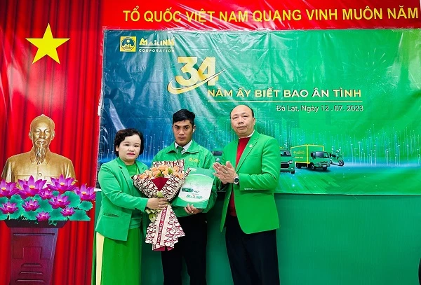 Ông Hồ Phụng Hoàng - Giám đốc Mai Linh Vùng 5, Giám đốc Mai Linh Đà Lạt (phải) và bà Vàng Bảo Thụy An - Phó Giám đốc phụ trách Tài chính Vùng 5 (trái) tặng hoa và giấy khen cho lái xe Trương Công Huy.