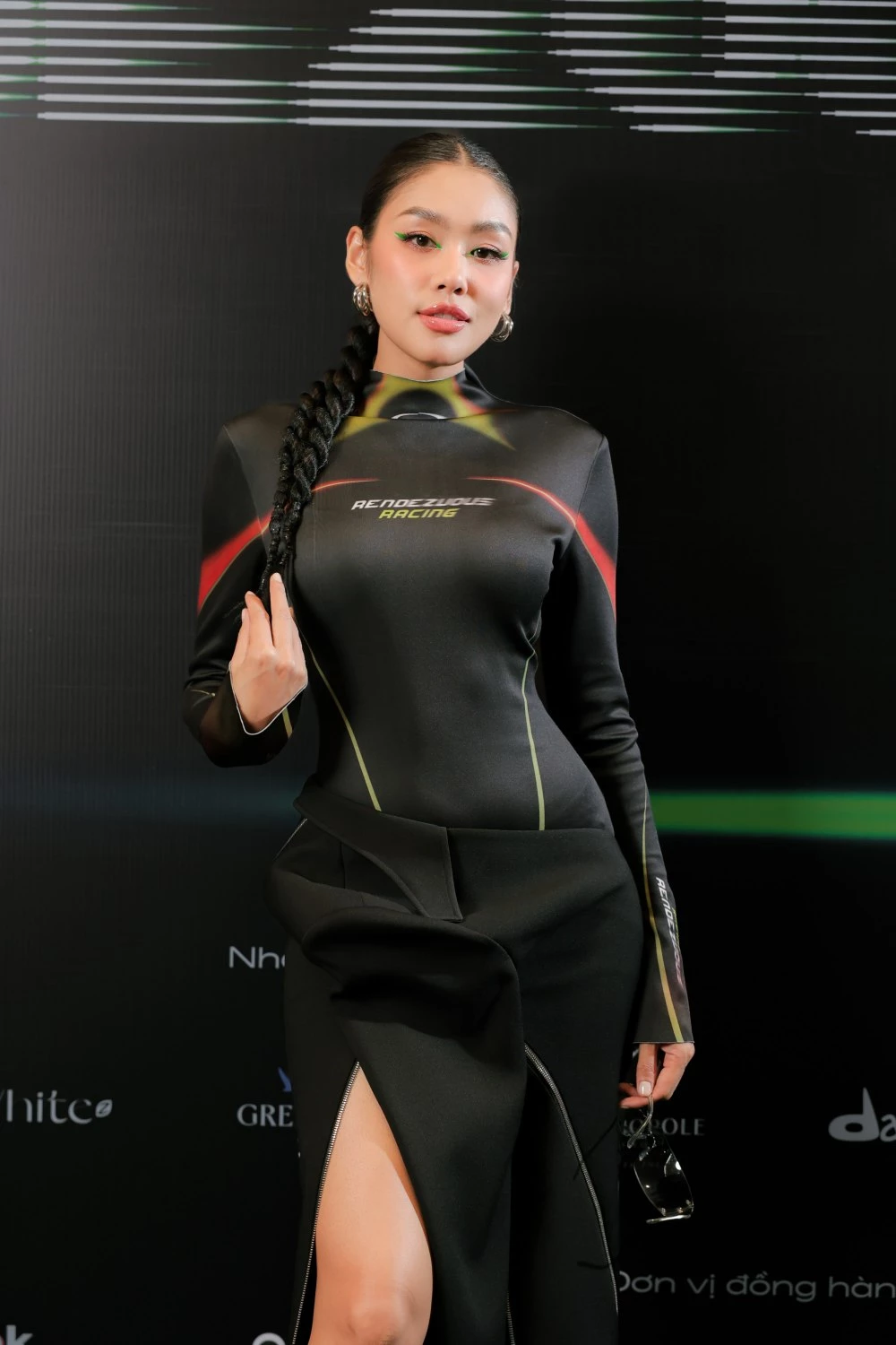 Thảo Nhi Lê trong thiết kế “Racer Bodysuit” với kiểu dáng jumpsuit dài tay, phá cách cùng chân váy phi cấu trúc, được tạo hình từ áo vest và những đường khóa kim loại. 