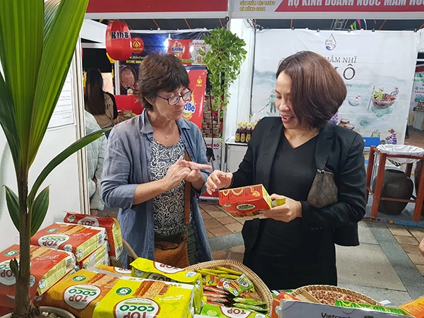 Bà Mai Thị Ý Nhi - Giám đốc Công ty TNHH Mỹ Phương Food trực tiếp giới thiệu sản phẩm OCOP bánh dừa nướng mè với nhà nhập khẩu nước ngoài.