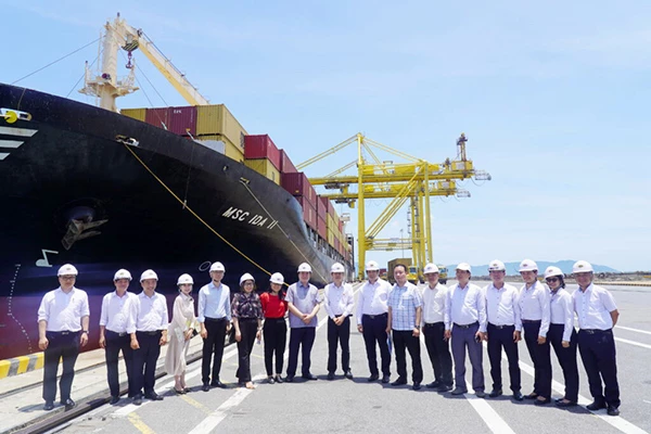 Thứ trưởng Bộ Công Thương Nguyễn Sinh Nhật Tân cùng đoàn công tác chụp ảnh lưu niệm với tàu vận tải container đang làm hàng tại cảng Tiên Sa.