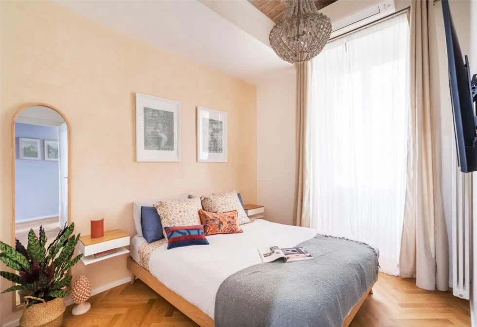 Phòng ngủ master của căn hộ với khung cửa sổ cỡ lớn, tối ưu ánh sáng tự nhiên vào bên trong. Phòng được sơn màu cam đào tạo cảm giác nhẹ nhàng, dễ chịu.
