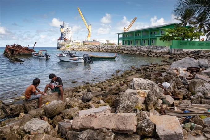 Những cậu bé làm sạch cá dọc theo bờ biển của Đảo Ebeye trong đảo san hô Kwajalein của Quần đảo Marshall vào tháng 7/2019 (Ảnh: CNN).