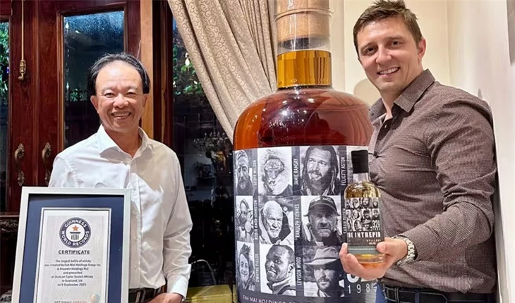 Ông Nguyễn Đình Tuấn Việt bên cạnh chai rượu whisky lớn nhất thế giới. (Ảnh: P.A.).