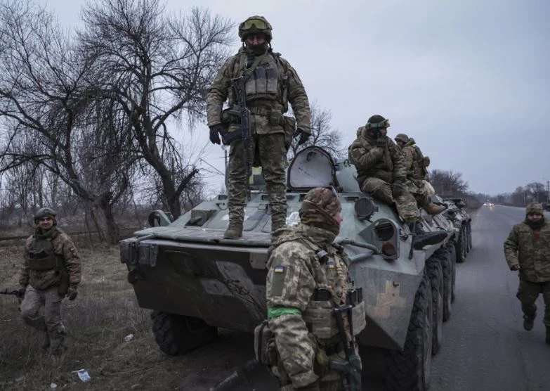 Binh sĩ Ukraine đứng trên nóc xe thiết giáp chở quân trước khi tiến ra tiền tuyến ở khu vực Donetsk, miền đông Ukraine. Ảnh: AP.
