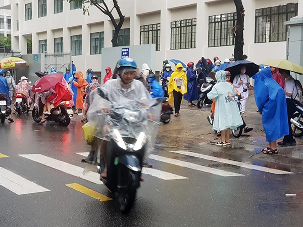 Phụ huynh ở Đà Nẵng đến trường đón con phải nghỉ học từ trưa 13/10 do mưa lớn gây ngập nhiều nơi.
