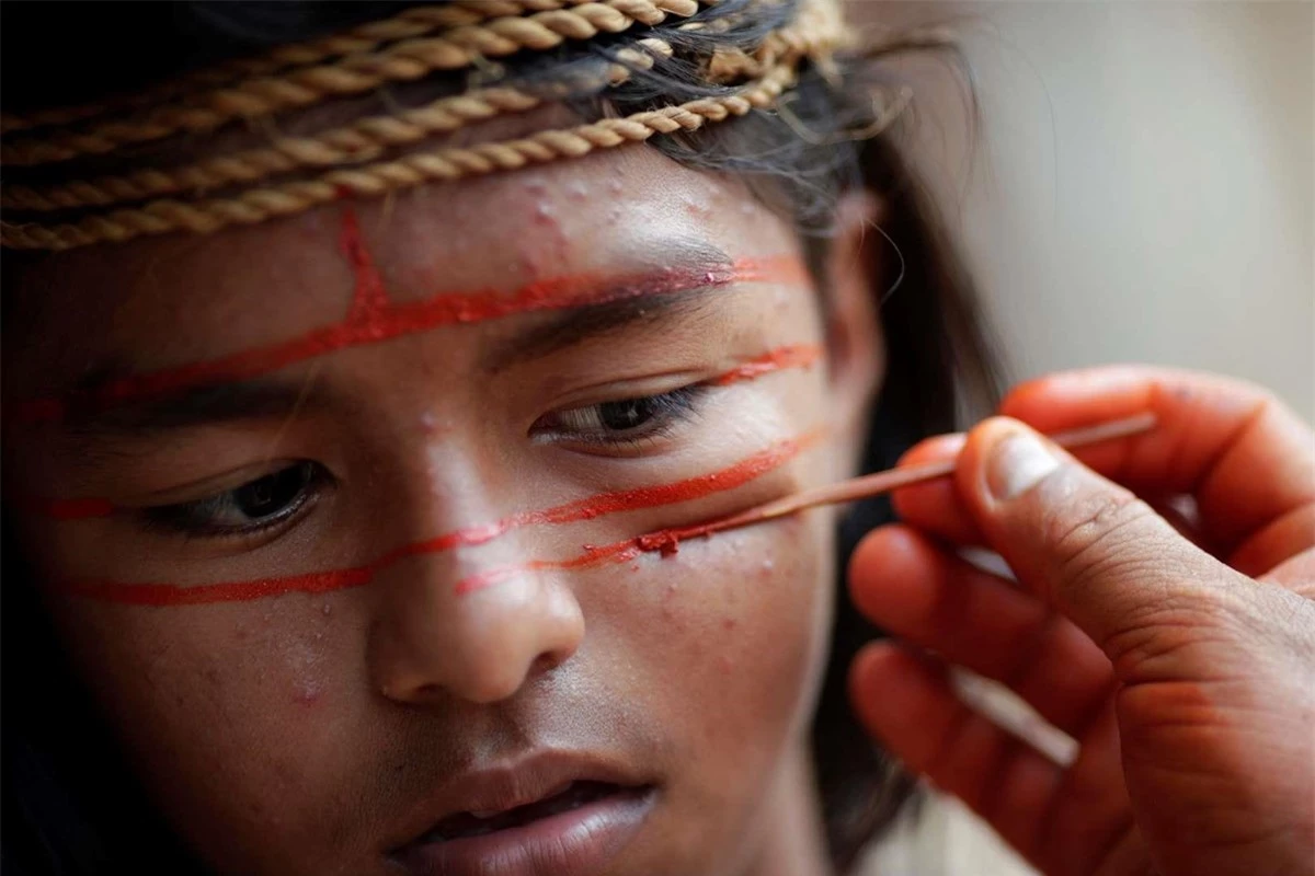 Các thành viên bộ lạc thổ dân Mura dùng sơn đỏ cam để hóa trang theo phong tục để gửi đến truyền thông quốc tế thông điệp bảo tồn rừng Amazon. Ảnh: Reuters.