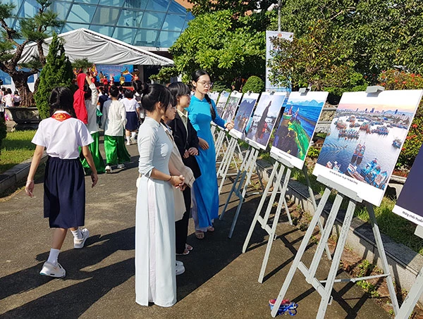 Các em học sinh thưởng lãm triển lãm ảnh “Chuyện làng biển”.