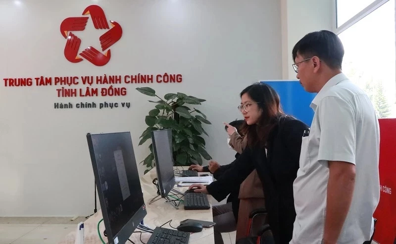 Cán bộ Trung tâm phục vụ hành chính công tỉnh Lâm Đồng hướng dẫn người dân nộp hồ sơ qua mạng.