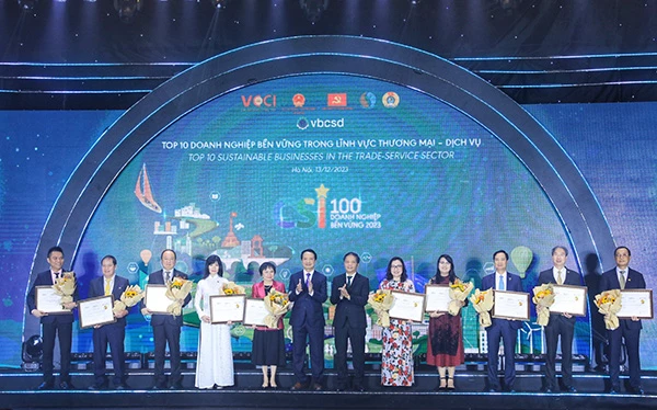 Ông Trần Tuấn Anh, Ủy viên Bộ Chính trị – Trưởng Ban Kinh tế TW và ông Nguyễn Quang Vinh – Phó Chủ tịch VCCI (đứng giữa) trao Giấy chứng nhận cho Top 10 Doanh nghiệp tiêu biểu lĩnh vực thương mại - dịch vụ năm 2023.