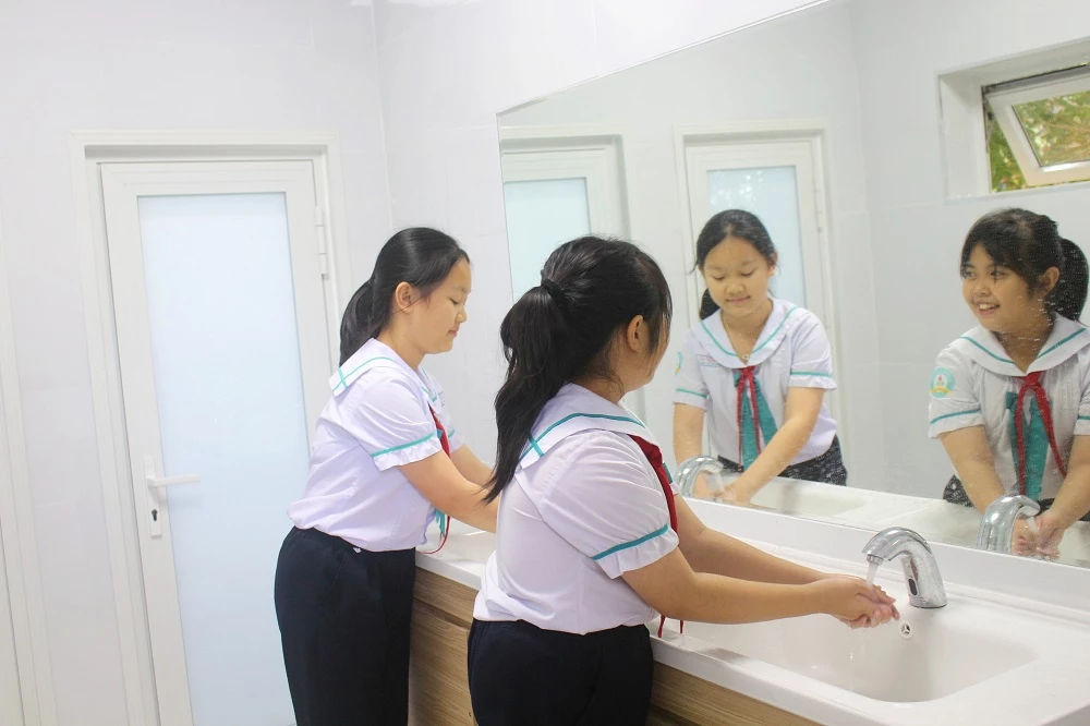 Các em học sinh phấn khởi khi được sử dụng nhà vệ sinh khang trang, sạch đẹp.