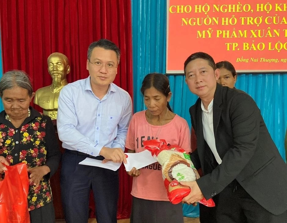 Ông Nguyễn Tiến Dũng - Bí thư Huyện ủy Cát Tiên (bên trái) và ông Phạm Minh Đăng – Giám đốc Mỹ phẩm Xuân Trang, trao quà Tết cho người dân.