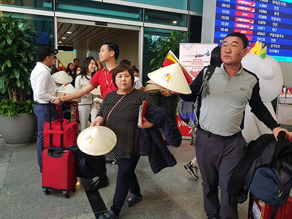 Du khách được tặng quà mừng năm mới 2024 là những chiếc nón lá truyền thống Việt Nam.