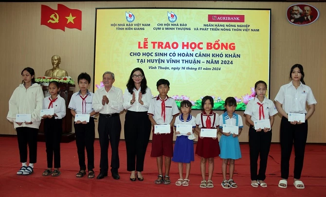 Nhà báo Lê Thành Phương và bà Ngô Thị Minh Thảo trao học bổng các em học sinh nghèo huyện Vĩnh Thuận