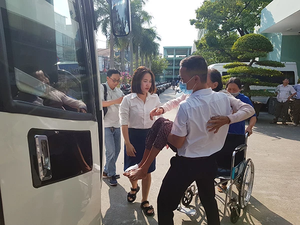 Cán bộ Phòng Công tác xã hội Bệnh viện Đà Nẵng đưa các bệnh nhân nặng lên xe về quê đón Tết.
