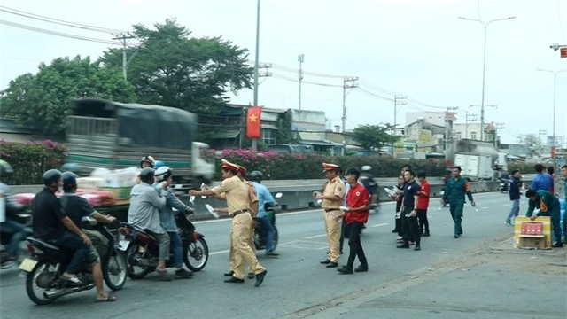 Cảnh sát giao thông phát nước, khăn lạnh miễn phí hỗ trợ người dân về quê đón Tết - Ảnh 2.