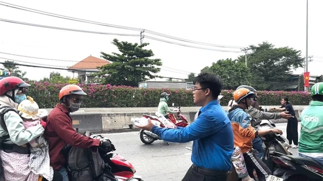 Cảnh sát giao thông phát nước, khăn lạnh miễn phí hỗ trợ người dân về quê đón Tết - Ảnh 3.