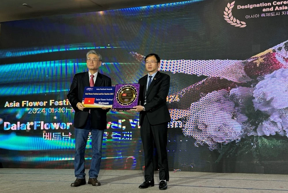 Ông Đặng Quang Tú – Chủ tịch UBND TP Đà Lạt (bên phải), đón nhận danh hiệu từ đại diện Hiệp hội Festival và sự kiện quốc tế - khu vực châu Á.