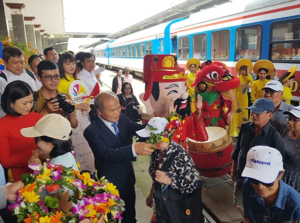 Tặng hoa chào đón du khách trên đoàn tàu "Kết nối di sản miền Trung" đến Đà Nẵng ngày 26/3.