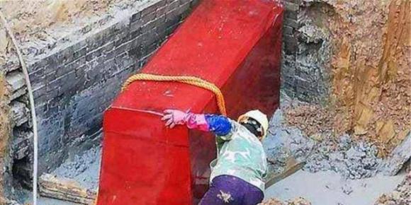 Cỗ quan tài khổng lồ màu đỏ được khai quật, trong đó là một hài cốt nữ, sau khi quần áo được vén lên khiến các chuyên gia kinh hãi