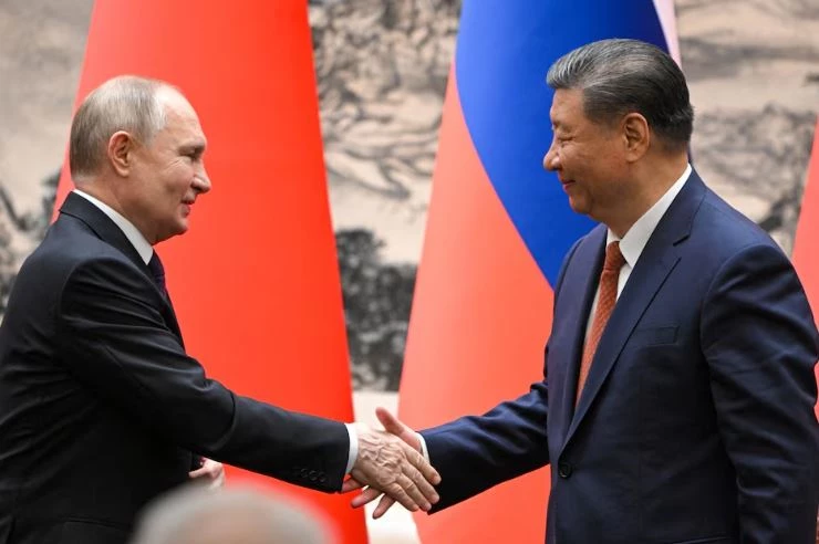 Tổng thống Nga Vladimir Putin (trái) bắt tay Chủ tịch Trung Quốc Tập Cận Bình trong cuộc gặp ở Bắc Kinh, Trung Quốc ngày 16/5. Ảnh: Reuters