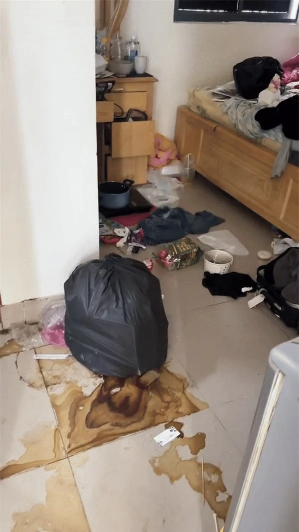 Căn phòng bị bao phủ khắp nơi đều là rác thải, quần áo, bát đũa bẩn, chai lọ, đồ ăn, hộp nhựa chất đống trong nhà