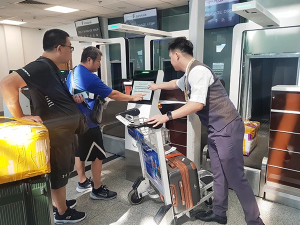 Nhân viên hãng hàng không Starlux Airlines hướng dẫn hành khách sử dụng hệ thống Self-bag drop (ký gửi hành lý tự động) tại nhà ga quốc tế T2 sân bay Đà Nẵng.