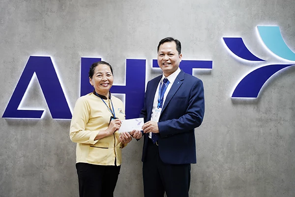 Ông Lê Trí Sơn trao tặng số tiền 5 triệu đồng của lãnh đạo Công ty AHT khen thưởng chị Trần Thị Hường.
