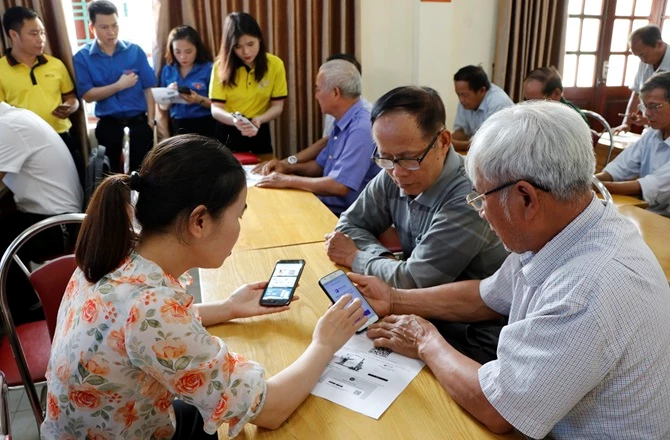Thành viên Tổ công nghệ số cộng đồng hỗ trợ người dân cài đặt ứng dụng số và sử dụng dịch vụ công trực tuyến