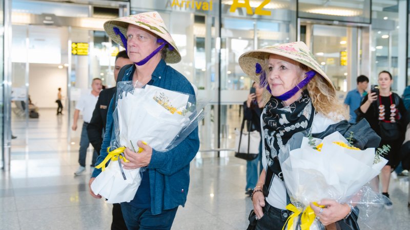 Thành viên Secret Garden thích thú khi được tặng nón lá vẽ tay thủ công ở sân bay Việt Nam