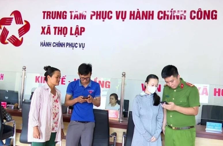 Cán bộ, đoàn viên thanh niên xã Thọ Lập hỗ trợ, hướng dẫn người dân sử dụng các dịch vụ ứng dụng trên điện thoại thông minh khi đến làm việc tại Trung tâm Phục vụ hành chính công xã. Ảnh: Báo Thanh Hóa.