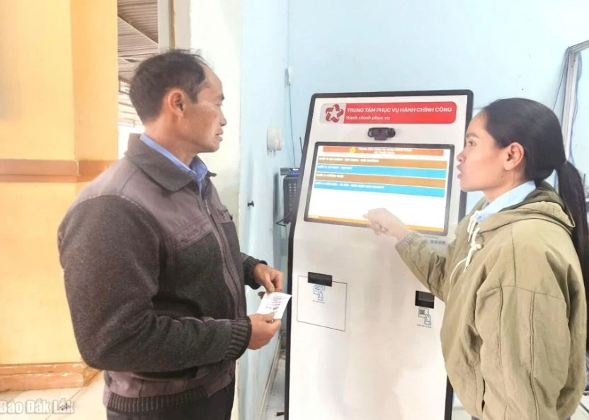Cán bộ xã Yang Mao hướng dẫn người dân sử dụng máy bấm số thứ tự. Ảnh: Báo Đắk Lắk.
