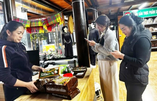 Nhân viên Điểm dừng nghỉ Phương Lâm, xã Đông Khê giới thiệu sản phẩm cho du khách. Ảnh: Báo Cao Bằng.