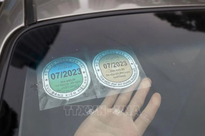 Dán thẻ đăng kiểm sau khi hoàn thành khám xe tại Trung tâm Đăng kiểm 29-03V. Ảnh: Huy Hùng/TTXVN.