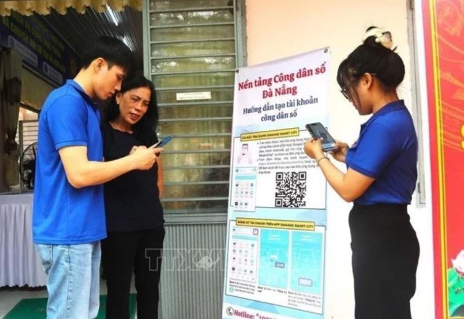 Các thành viên của Tổ Công nghệ số cộng đồng và Đề án 06 tại TP Đà Nẵng hướng dẫn người dân nộp hồ sơ dịch vụ công trực tuyến. Ảnh: Báo Tin tức.