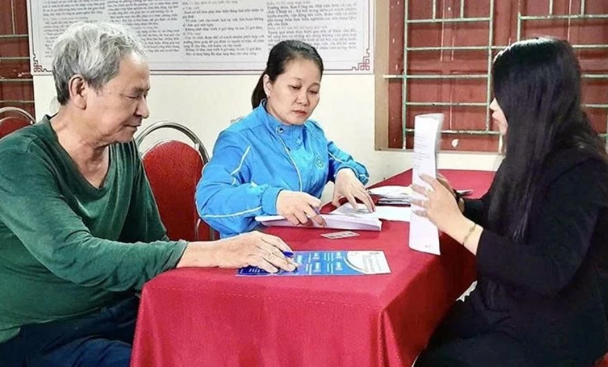 Cán bộ BHXH cơ sở Yên Định tuyên truyền, vận động người dân nhận chế độ BHXH qua tài khoản cá nhân. Ảnh: Báo Thanh Hóa.