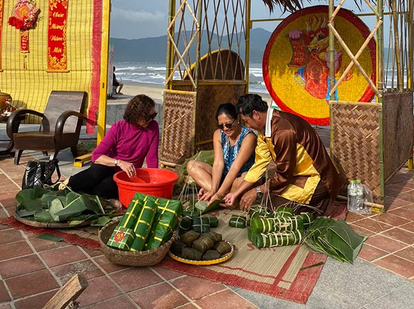 Du khách nước ngoài trải nghiệm gọi bánh chưng trong chương trình "Xuân yêu thương" do BQL bán đảo Sơn Trà và các bãi biển du lịch Đà Nẵng tổ chức.