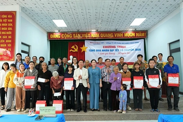 Bà Huỳnh Thuý Vân - Phó Chủ tịch HĐND tỉnh Gia Lai và ông Nguyễn Văn Lăng - Tổng giám đốc Becamex Bình Định (vest trắng), trao quà cho các hộ dân.