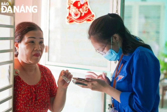 Đoàn viên, thanh niên quận Sơn Trà (bên phải) hướng dẫn người dân sử dụng các dịch vụ công điện tử. Ảnh: Báo Đà Nẵng.