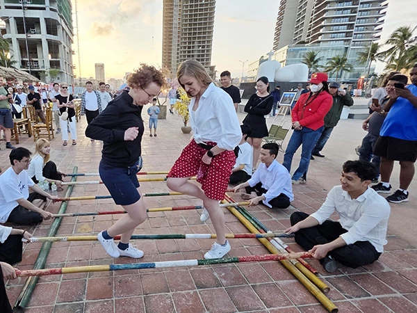 Du khách nước ngoài hào hứng trả nghiệm trò chơi dân gian nhảy sạp.