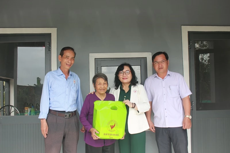 Bà Quang Cẩm Thu - Chi hội trưởng Chi hội Bác Ái Tuy Phước (thuộc Hội Bảo trợ bệnh nhân nghèo tỉnh Gia Lai) trao quà cho gia đình bà Phan Thị Phong 