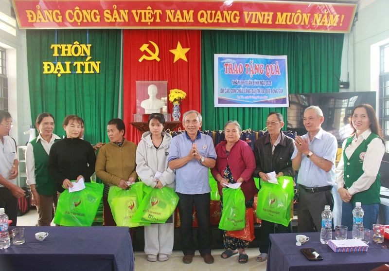 Ông Phan Minh Hải cùng đại diện gia đình con em xa quê tặng quà cho người dân. 
