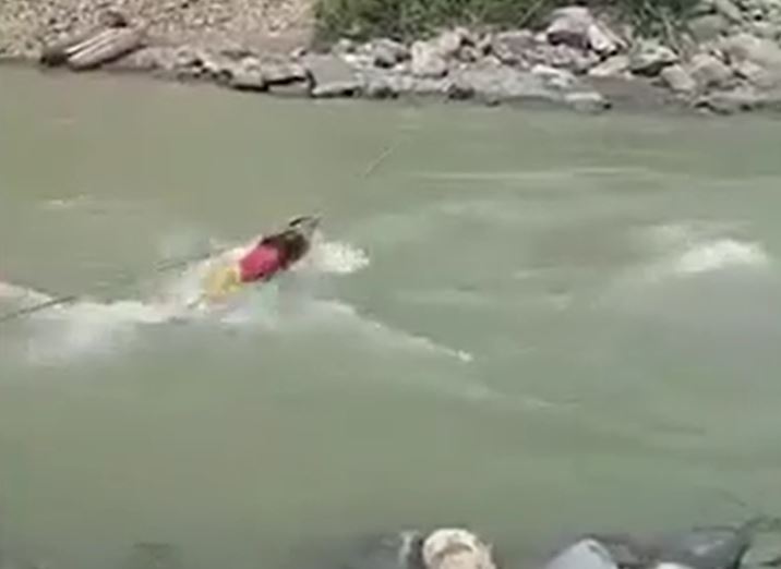 Thót tim khoảnh khắc bé gái bám dây thừng vượt sông mùa lũ