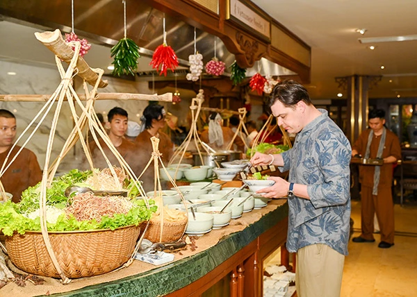 Du khách nước ngoài trải nghiệm ẩm thực Việt tại phiên chợ quê Tết.