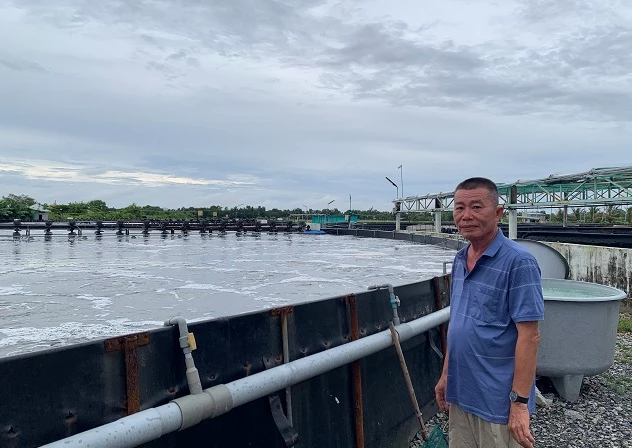 Ảnh 1: Ông Nguyễn Việt Khởi bên một ao nuôi tôm trên mặt đất.