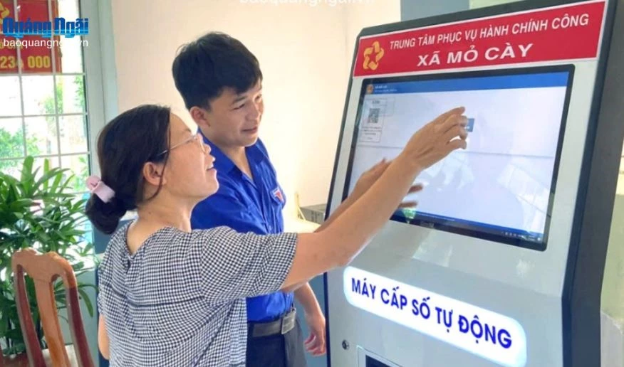 Người dân lấy số thứ tự tự động tại Trung tâm Phục vụ hành chính công xã Mỏ Cày. Ảnh: Báo Quảng Ngãi.